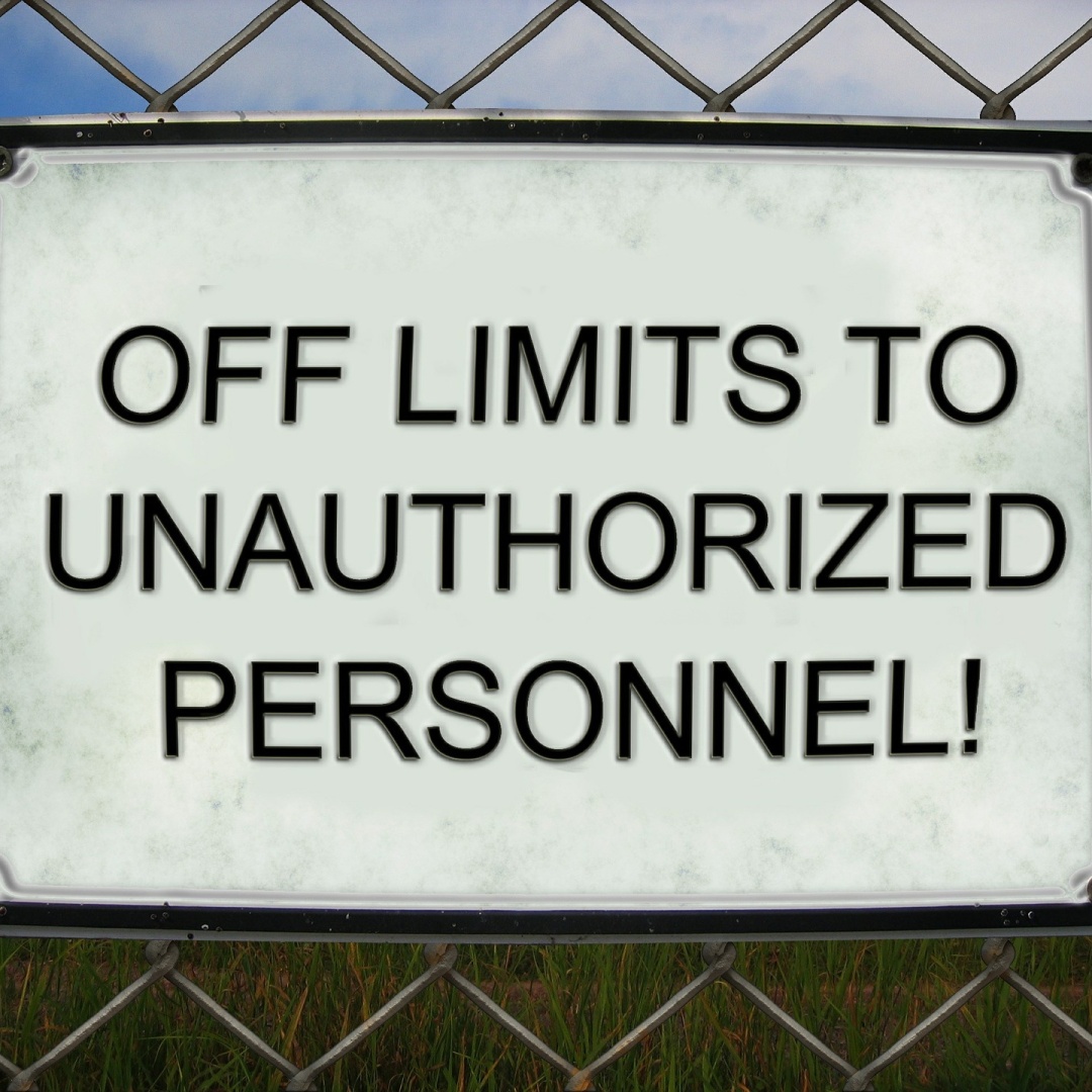 A sign on chain-link fence that reads "Off limits to unauthorized personnel!